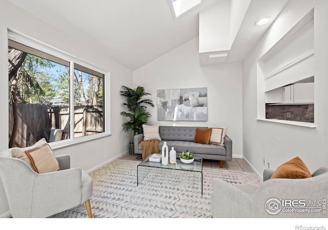 living room featuring baseboards and lofted ceiling