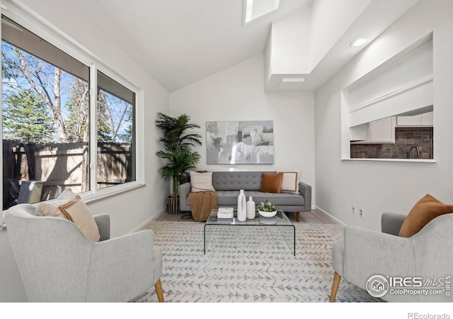 living room featuring lofted ceiling and baseboards