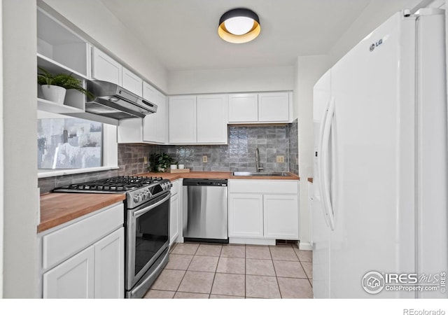 kitchen featuring appliances with stainless steel finishes, wooden counters, white cabinetry, and a sink