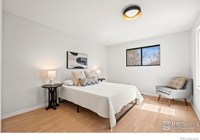 bedroom featuring wood finished floors and baseboards