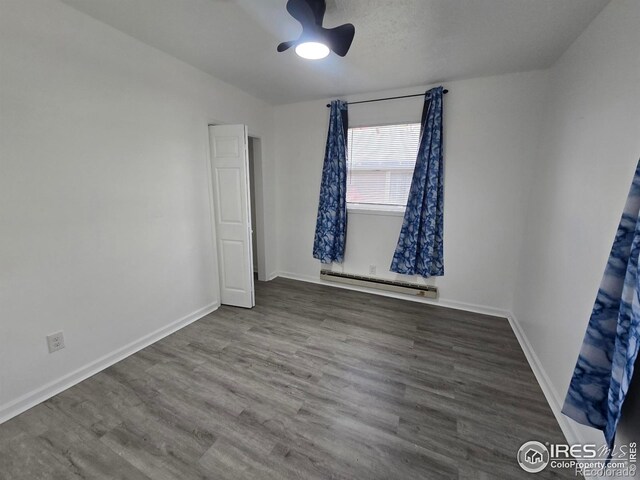 409 N 4th Ave, Sterling, CO 80751 - spare room featuring a baseboard radiator, wood finished floors, and baseboards