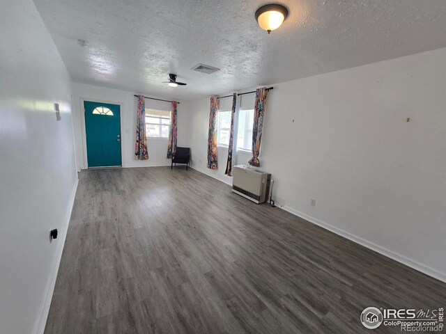 409 N 4th Ave, Sterling, CO 80751 - unfurnished living room with a textured ceiling, wood finished floors, and baseboards