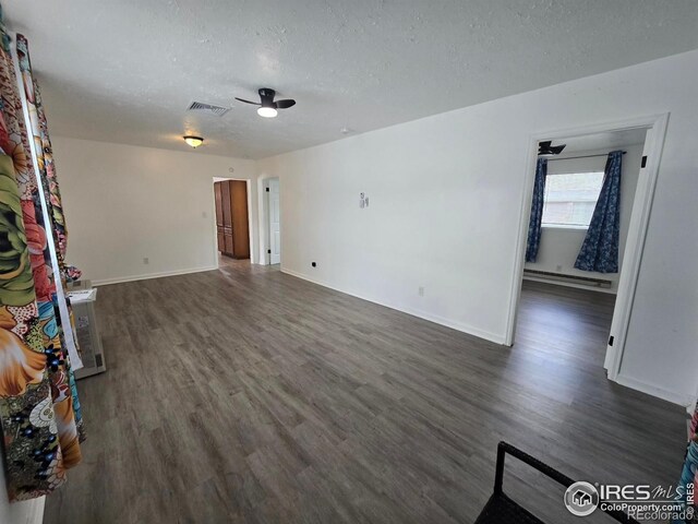 409 N 4th Ave, Sterling, CO 80751 - unfurnished living room with wood finished floors, a textured ceiling, baseboards, a baseboard heating unit, and ceiling fan