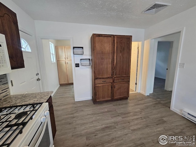 409 N 4th Ave, Sterling, CO 80751 - kitchen with dark wood-style floors, baseboards, and a baseboard heating unit