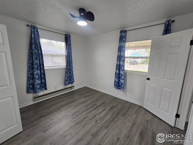 409 N 4th Ave, Sterling, CO 80751 - unfurnished room featuring a baseboard heating unit, wood finished floors, a textured ceiling, and baseboards