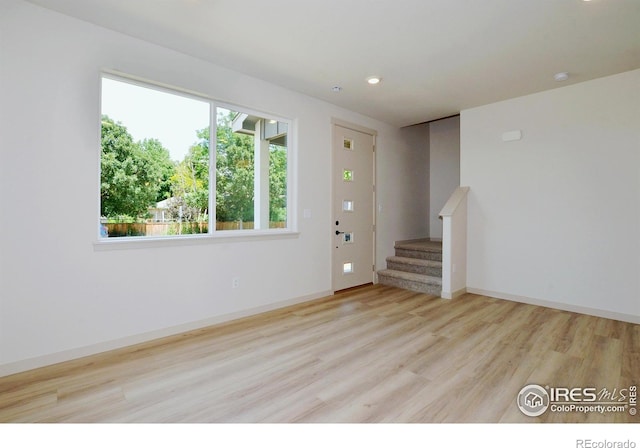 1039 Spartan Ave, Berthoud, CO 80513 - unfurnished living room with baseboards, stairs, wood finished floors, and recessed lighting