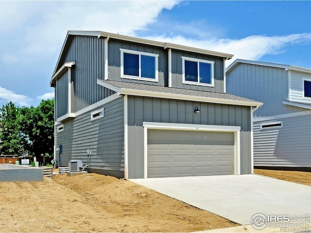 1039 Spartan Ave, Berthoud, CO 80513 - view of front facade with an attached garage, board and batten siding, central air condition unit, and concrete driveway