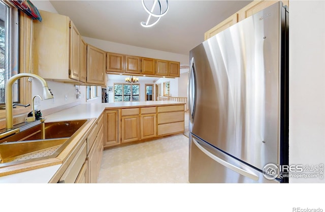 1162 Fairway Club Ln Unit 1, Estes Park, CO 80517 - kitchen featuring light floors, light countertops, light brown cabinets, a sink, and freestanding refrigerator