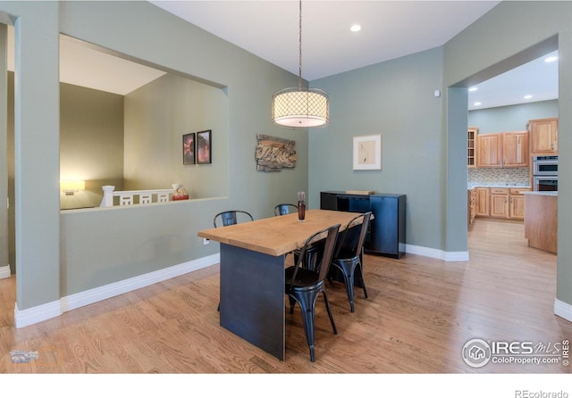 dining space with light wood-type flooring, baseboards, and recessed lighting
