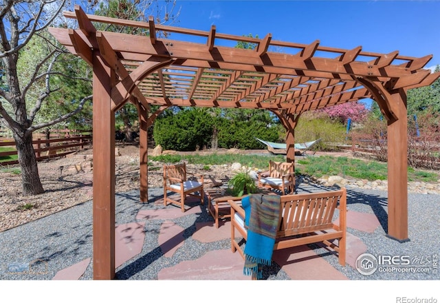 view of patio with a pergola and fence