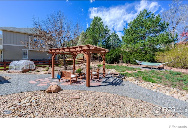 view of patio / terrace with a pergola, an outbuilding, and a greenhouse