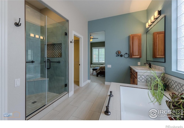 ensuite bathroom with a wealth of natural light, vanity, ensuite bathroom, and a stall shower