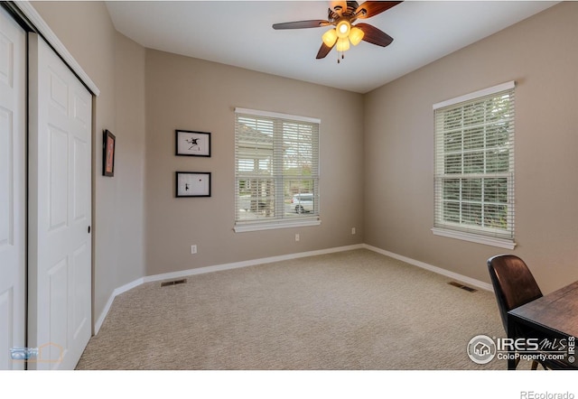unfurnished office featuring visible vents, carpet floors, and ceiling fan