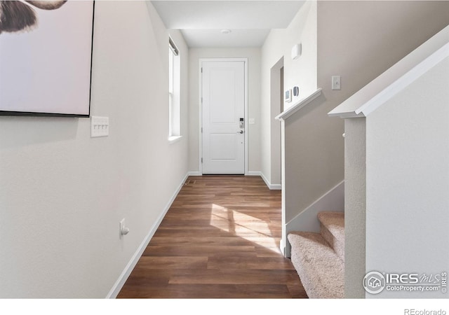 interior space featuring wood finished floors, stairs, and baseboards
