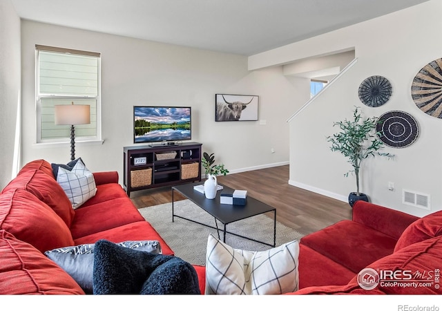 living room with baseboards, wood finished floors, and visible vents