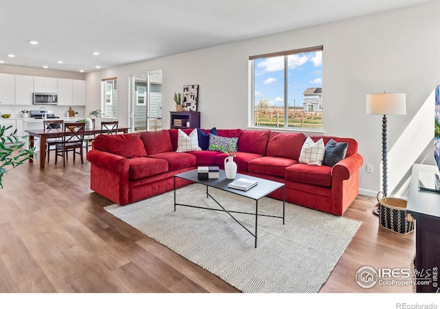 living area featuring recessed lighting, light wood-style flooring, and plenty of natural light