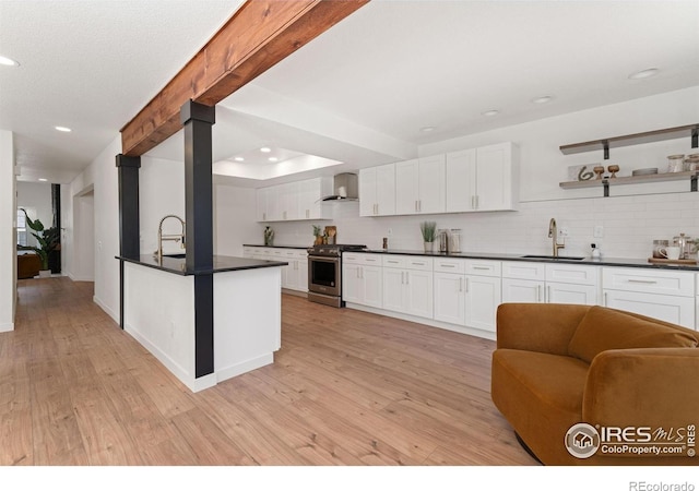 7102 S Harrison Ct, Centennial, CO 80122 - kitchen with stainless steel gas range oven, wall chimney exhaust hood, a sink, dark countertops, and backsplash