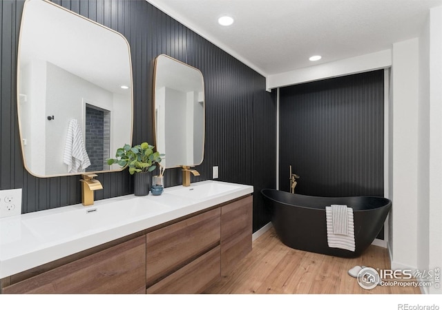 7102 S Harrison Ct, Centennial, CO 80122 - full bath featuring wood finished floors, double vanity, a freestanding tub, and recessed lighting