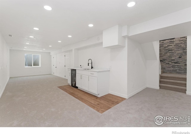 7102 S Harrison Ct, Centennial, CO 80122 - below grade area with light colored carpet, recessed lighting, wet bar, baseboards, and stairs