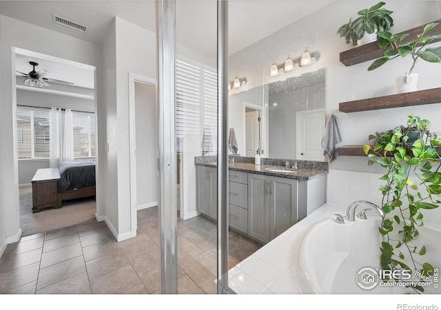 ensuite bathroom with a bath, vanity, ceiling fan, tile patterned flooring, and visible vents