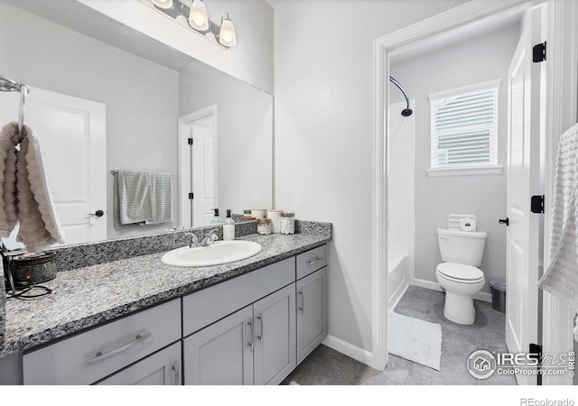 bathroom featuring toilet, vanity, tub / shower combination, and baseboards