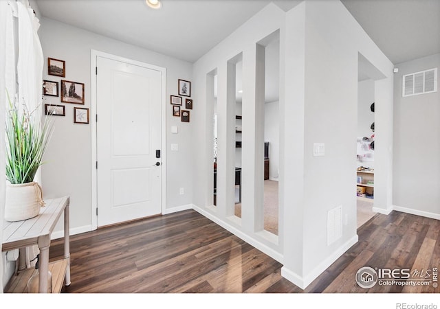 foyer entrance featuring baseboards, dark wood-style flooring, visible vents, and recessed lighting