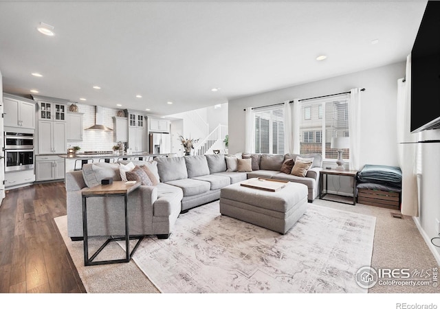 living area with recessed lighting, dark wood finished floors, stairway, and visible vents