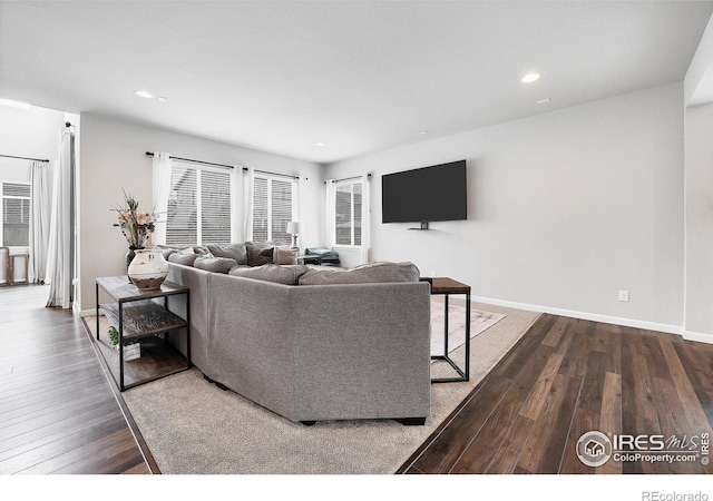 living area featuring baseboards, dark wood-style flooring, and recessed lighting