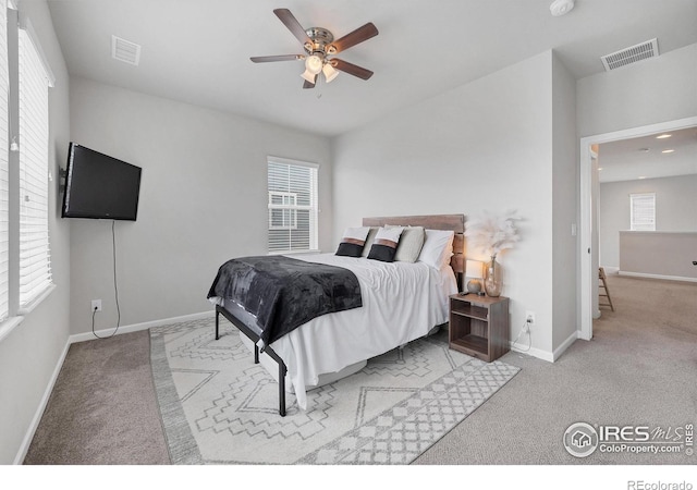 carpeted bedroom featuring baseboards, multiple windows, and visible vents