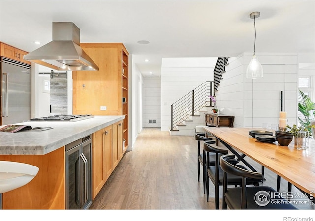 kitchen featuring island exhaust hood, recessed lighting, wine cooler, and wood finished floors