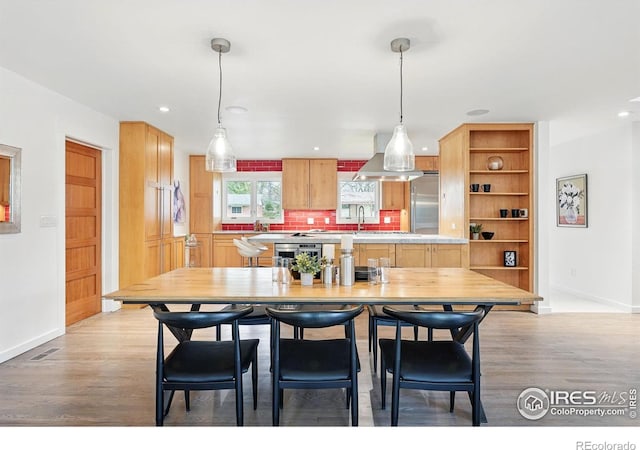 dining room featuring recessed lighting, baseboards, and light wood-style flooring