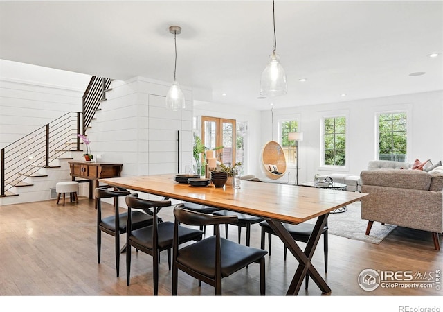 dining area with light wood-type flooring, recessed lighting, and stairs