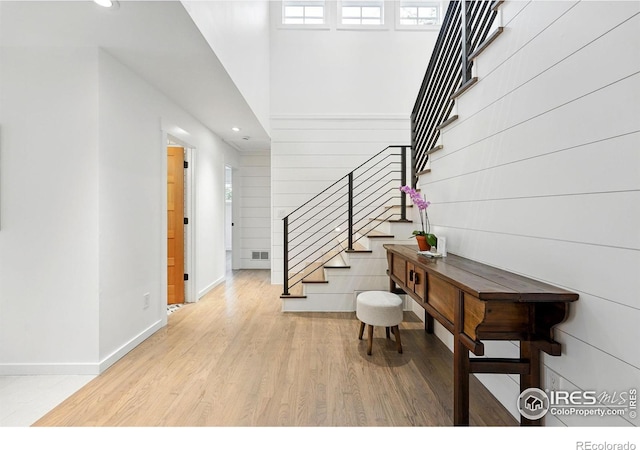 foyer entrance featuring stairway, baseboards, plenty of natural light, and wood finished floors