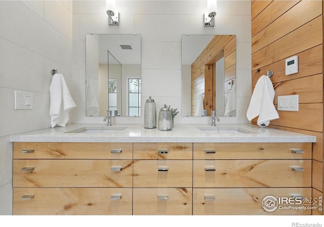 bathroom featuring double vanity, visible vents, and a sink