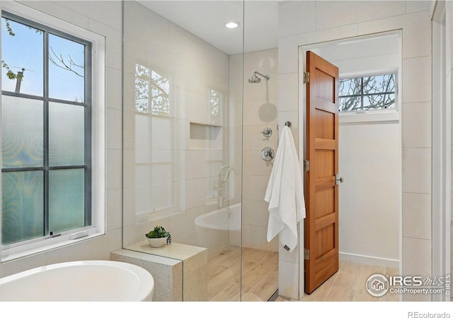 full bath with a tile shower, recessed lighting, a garden tub, and wood finished floors
