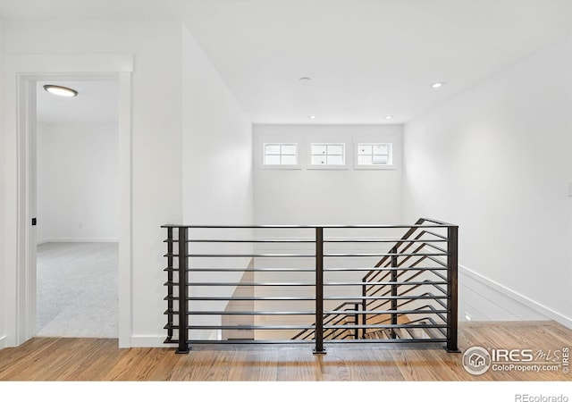 interior space featuring recessed lighting, baseboards, an upstairs landing, and wood finished floors