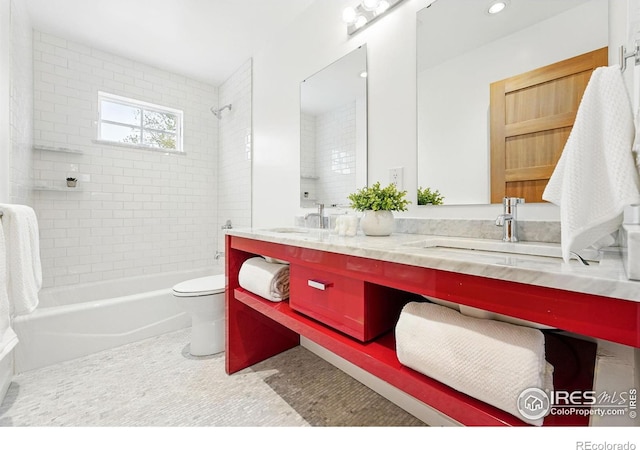 bathroom with a sink, bathtub / shower combination, toilet, and double vanity