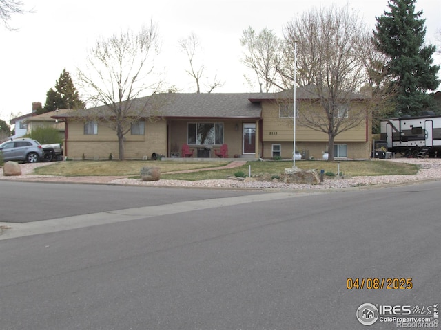 split level home with brick siding and a front lawn