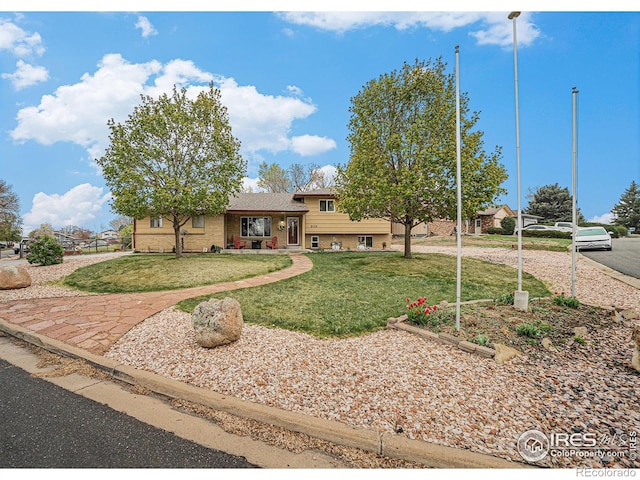split level home with brick siding and a front yard
