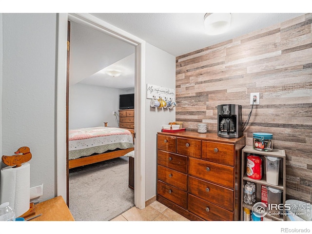 carpeted bedroom featuring wooden walls and tile patterned floors