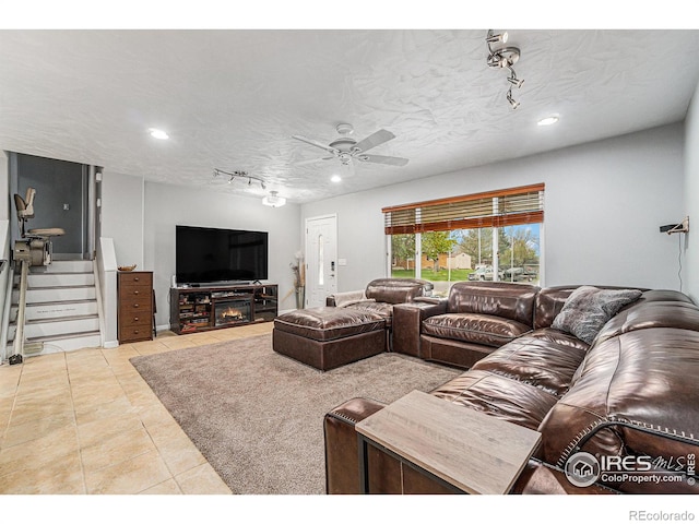 tiled living area with stairs, a ceiling fan, rail lighting, and recessed lighting
