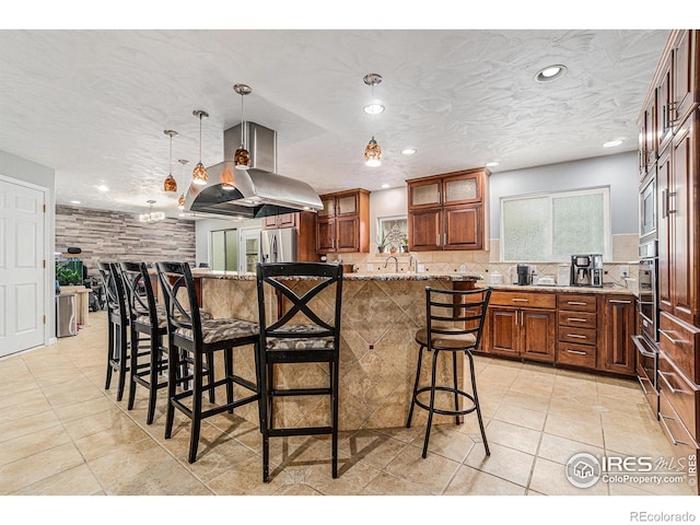 kitchen featuring a breakfast bar, recessed lighting, light stone counters, backsplash, and stainless steel appliances