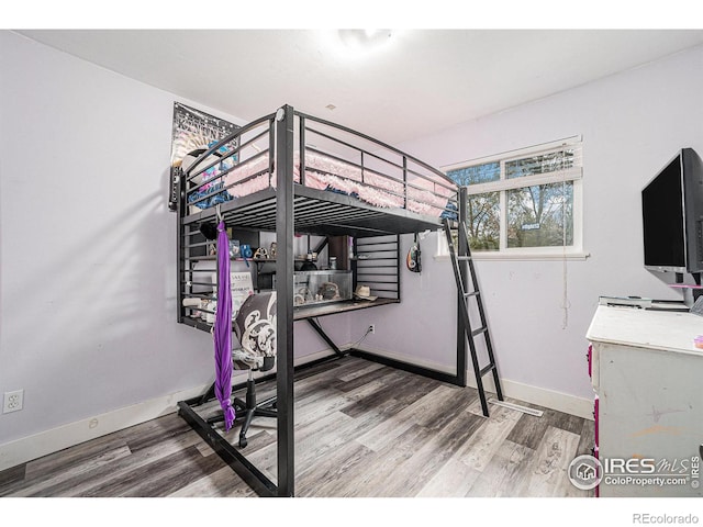 bedroom with baseboards and wood finished floors