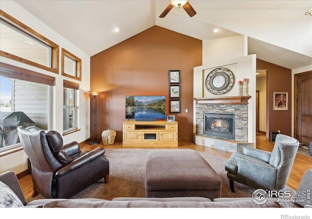 3560 Peruvian Torch Dr, Loveland, CO 80537 - living room featuring ceiling fan, wood finished floors, a stone fireplace, high vaulted ceiling, and recessed lighting