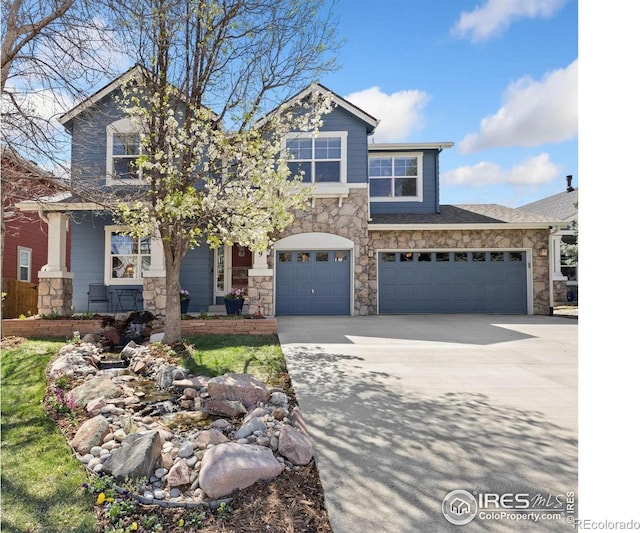 craftsman house with a garage, driveway, and stone siding
