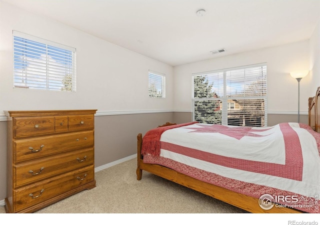 carpeted bedroom with visible vents and baseboards