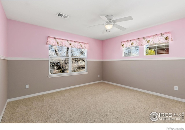 unfurnished room with visible vents, carpet flooring, ceiling fan, and a healthy amount of sunlight
