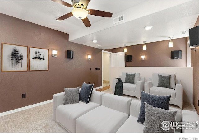 carpeted home theater room featuring visible vents, a ceiling fan, and baseboards