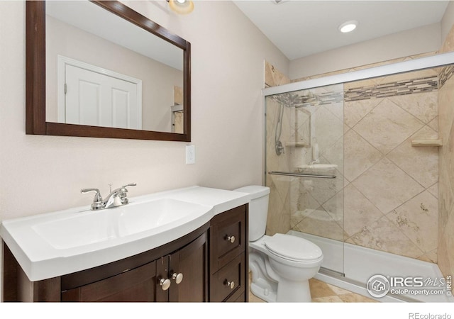 full bathroom featuring vanity, toilet, and a shower stall