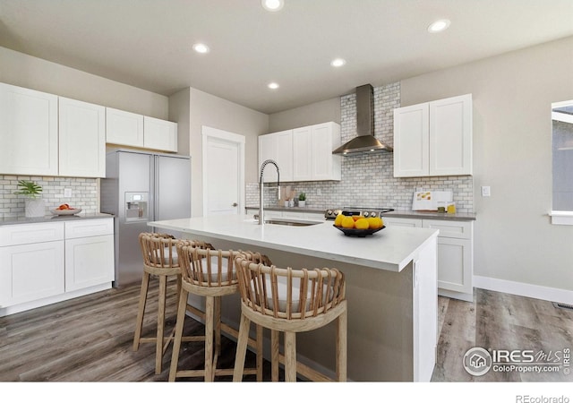 1755 Avery Plaza St, Severance, CO 80550 - kitchen with wall chimney exhaust hood, stainless steel appliances, a sink, decorative backsplash, and light wood-style flooring